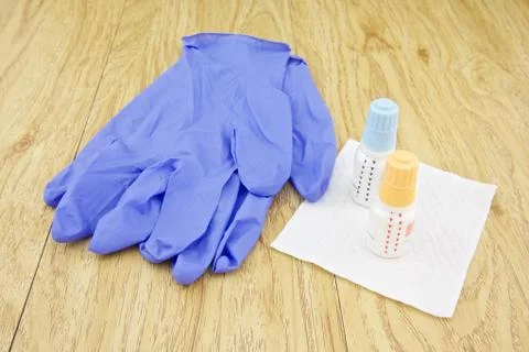 Eye drops put on tissue paper and latex glove Stock Photos