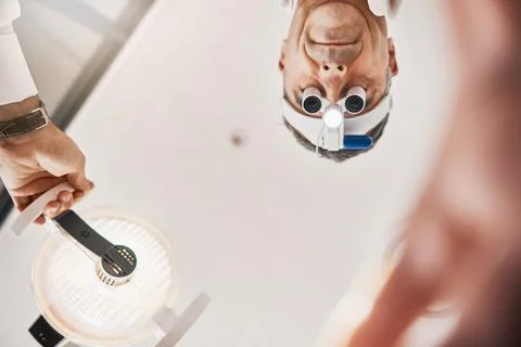 Eye exam, flashlight and face of optometrist looking down to patient for vision Stock Photos