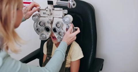 Eye exam, optometry and optician with child on phoropter for testing vision Video stock 255388299