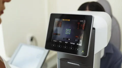 Eye examination process using an autorefractor, showing a close-up of the Stock Footage 339979698