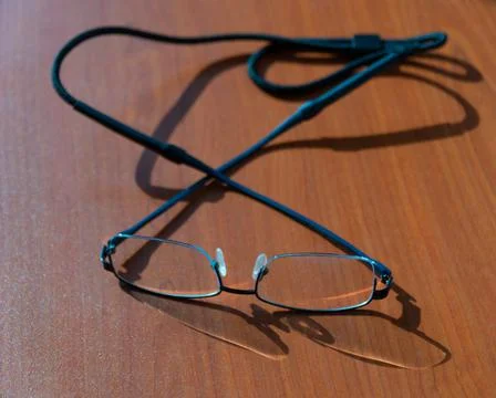 Eye glasses resting on a table Stock Photos