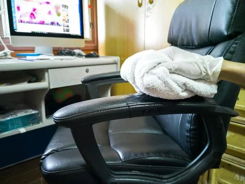 Eye level angle. cleaning a black work chair, using a check cloth 스톡 사진