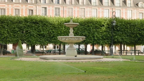 Eye-level centered view of a historic tiered stone fountain in Place des Vosges, Stock Footage 338007187