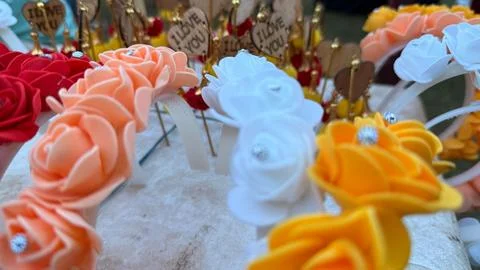 An eye-level close-up shows several colorful rose headbands, alongside blurre Fotos Stock