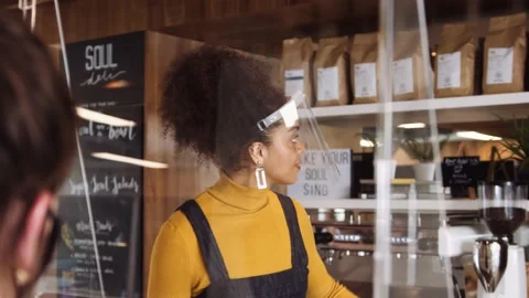 Eye Level Medium Close up, Female African coffee shop owner wearing face viso Stock Footage 138580452