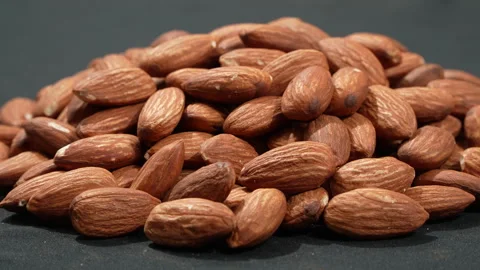 Eye Level Pile Of Raw Almonds Rotating On Black 4K Видео 332843435