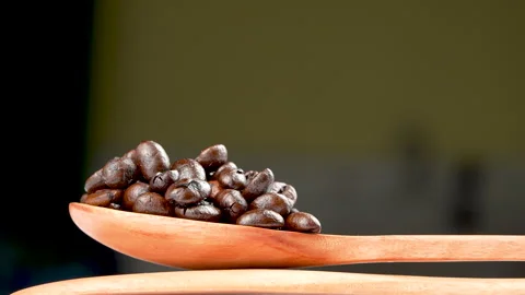 Eye Level Rotating Coffee Beans On Wooden Spoon Macro Video stock 331928283