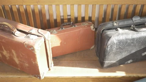 Eye level slider shot of old vintage suitcases sitting on a old stool Stock Footage 146012725