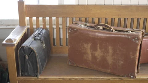 Eye level slider shot of old vintage travelling suitcases sitting on  old stool Stock Footage 146015238