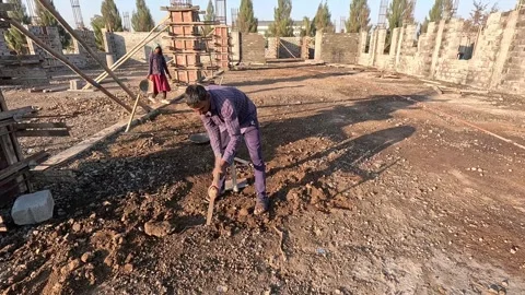 Eye level wide angle shot documenting a male manual construction builder using Stock Footage 337789738