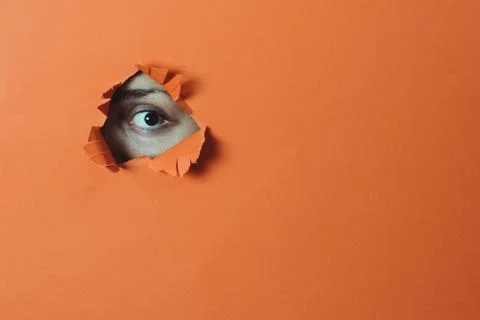 Eye looking through the hole Stock Photos