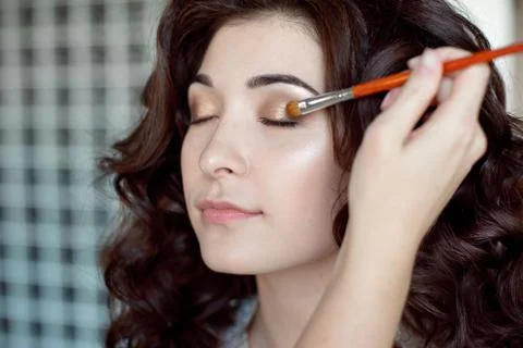 Eye makeup woman applying eyeshadow powder. Make up artist doing professional Stock Photos