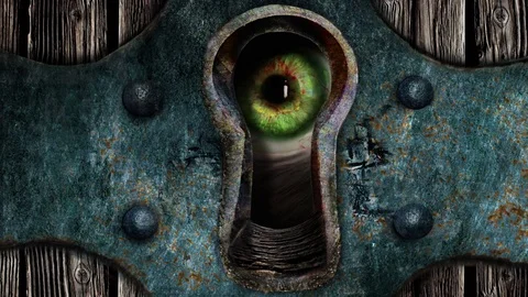 The eye seen through a keyhole. Disturbing, scary Stock Footage 81001737