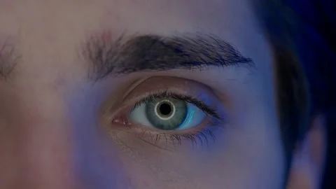 Eye of a young man macro shot. Blue light from a smartphone, computer screen is Stock Footage 256801262