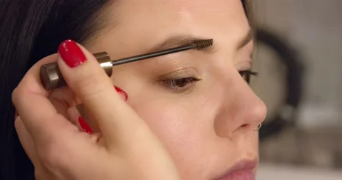 Eyebrow makeup close-up. Eye of a young woman during makeup Stock Footage 136552465