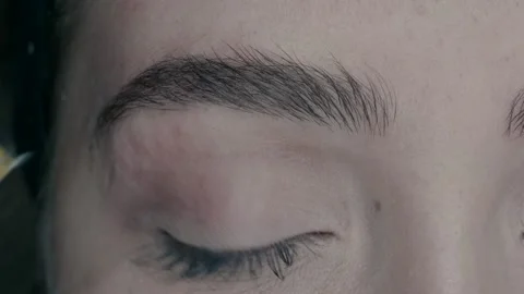 The eyebrow master combs the eyebrow after finishing the microblading work. Stock Footage 223152684