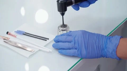 The eyebrow master mixes the paint with a special apparatus. Stock Footage 144639862