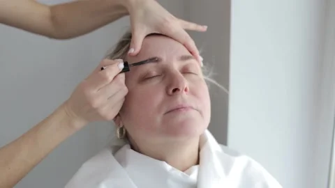 Eyebrow tinting brown. Correction and coloring of eyebrows for an adult woman Stock-Footage 222905826