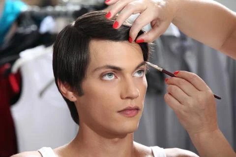 Eyebrows with makeup brush, model at mirror in dressing room Stock-Fotos