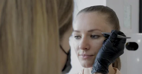 Eyebrows tweezing procedure footage. Brows correction with cosmetic tweezer. Stock Footage 115030493