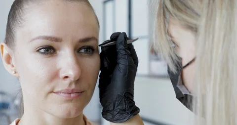 Eyebrows tweezing procedure footage. Brows correction with cosmetic tweezer. Stock Footage 115032177