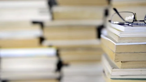 Eyeglass on books in focus Stock Footage 102728419