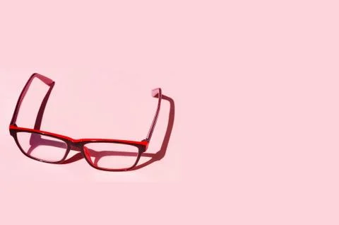 Eyeglass on pink background with shadows Stockfoto's