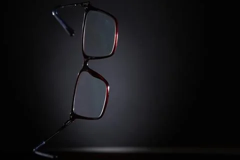 Eyeglasses angled front view with shadow on dark background Stock Photos