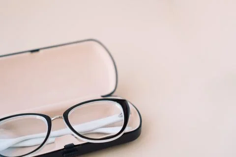 Eyeglasses with black frames in a light case on a light background Stock Photos