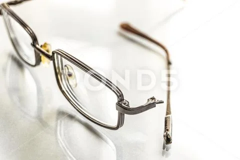 Eyeglasses with a broken shackle on a bright background Stock Photos