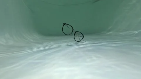 Eyeglasses falling and sinking underwater. glasses at the bottom of a pool Stock Footage 286065010