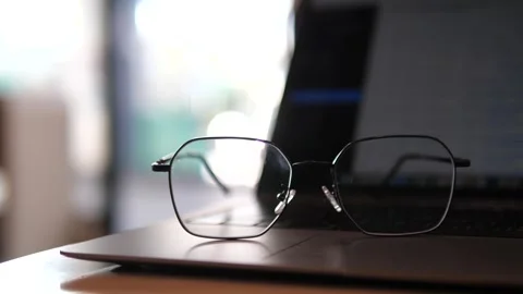 Eyeglasses on laptop with blurred background Stock Footage 320768834