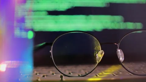 Eyeglasses on Laptop Keyboard With Defocused Computer Code on Screen Stock Footage 342185502
