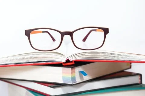 Eyeglasses on stack of books Stock Photos
