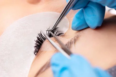 Eyelash extension procedure. The working process of professional beauty master Foto stock