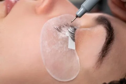Eyelash extension process. Close-up portrait of a young girl, a woman with ey Stock Photos