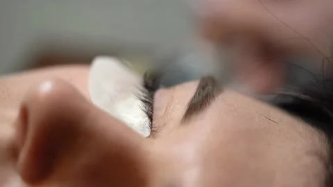 Eyelash extensions are done on young woman. Macro 库存影片 224546660