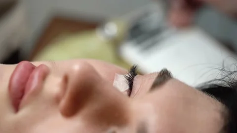 Eyelash extensions are done on young woman. Macro Vidéo 224958966
