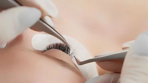 Eyelash extensions process includes applying individual lashes with precision by Stock Footage 276668361