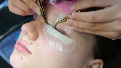 Eyelash extensions process includes applying individual lashes with precision by Stock Footage 322657355