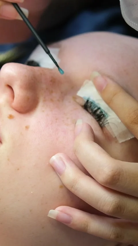 Eyelash extensions process includes applying individual lashes with precision by Stock Footage 324009716