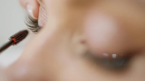 Eyelash tinting. Extreme close-up of makeup artist applying mascara to model Stock Footage 317084560