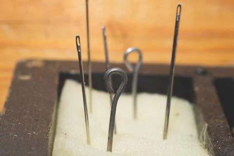 Eyelet of needle close up. needles is inserted into the foam rubber 写真素材