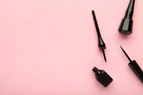 Eyeliners on pink background with copy space. Top view Stock Photos
