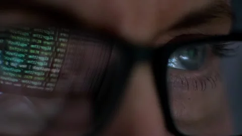 Eyes with glasses reflecting binary data, symbolizing technology and analysis Stock Footage 315339922