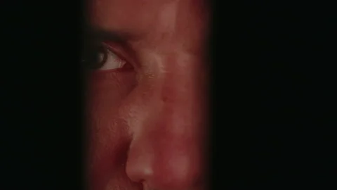Eyes of a man watching through a gap Stock-Footage 235930858