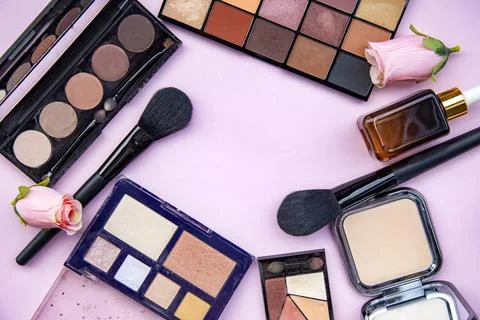 Eyeshadows and brushes on a pink background Stock Photos