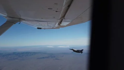 F-16 Fighting Falcon performing rolling movement from light aircraft Stock Footage 263722306