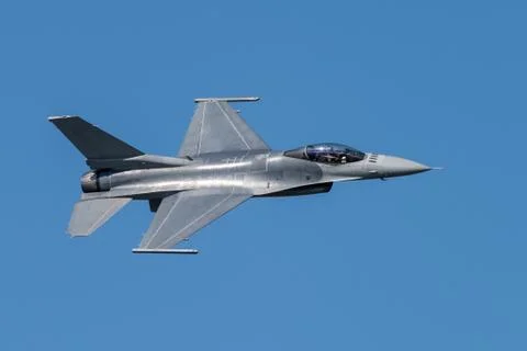 F-16 Fighting Falcon Silhouette in Clear Blue Sky with Fighter Pilot Visible Stock Photos