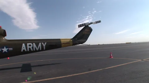 F-22 taxis down runway in the shadow of a Huey helicopter Stock Footage 45546993